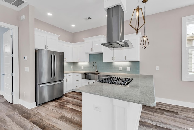 202 Clam Digger Loop, Pawleys Island, SC 29585 - kitchen featuring freestanding refrigerator, island range hood, a peninsula, wood finished floors, and light stone counters