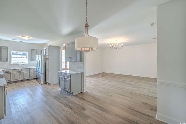 4000 Bayfield Loop, Murrells Inlet, SC 29576 - kitchen featuring gray cabinetry, freestanding refrigerator, tasteful backsplash, a chandelier, and light countertops