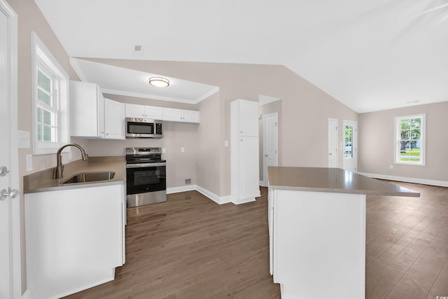 9655 Kings Grant Dr, Murrells Inlet, SC 29576 - kitchen with stainless steel appliances, wood finished floors, white cabinets, vaulted ceiling, and a kitchen island