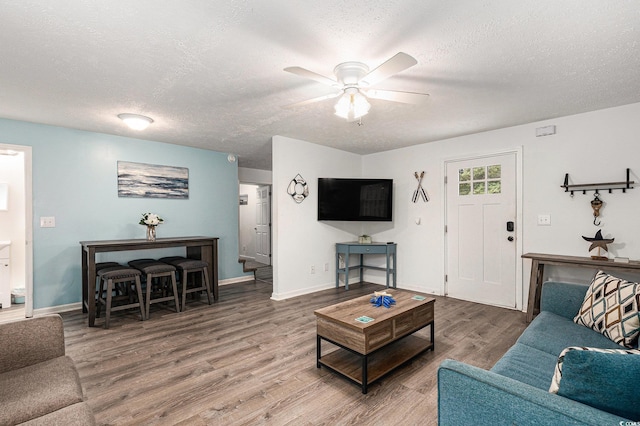 1005 28th Ave S, North Myrtle Beach, SC 29582 - living room featuring wood finished floors, a textured ceiling, and a ceiling fan