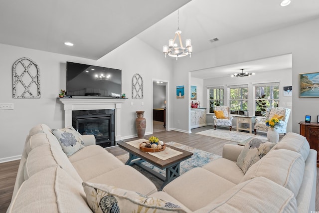 3909 On Deck Cir, Little River, SC 29566 - living room featuring a chandelier, wood finished floors, a glass covered fireplace, recessed lighting, and vaulted ceiling