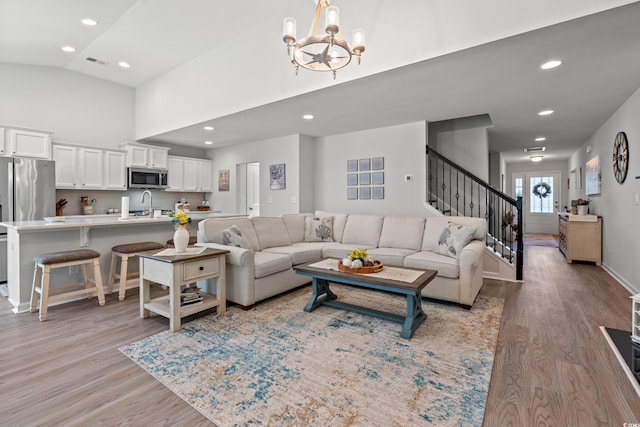 3909 On Deck Cir, Little River, SC 29566 - living room with a chandelier, light wood-style floors, stairs, high vaulted ceiling, and recessed lighting
