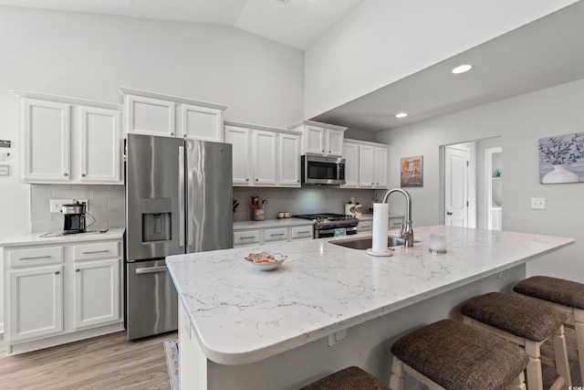 3909 On Deck Cir, Little River, SC 29566 - kitchen with stainless steel appliances, white cabinets, backsplash, an island with sink, and a breakfast bar