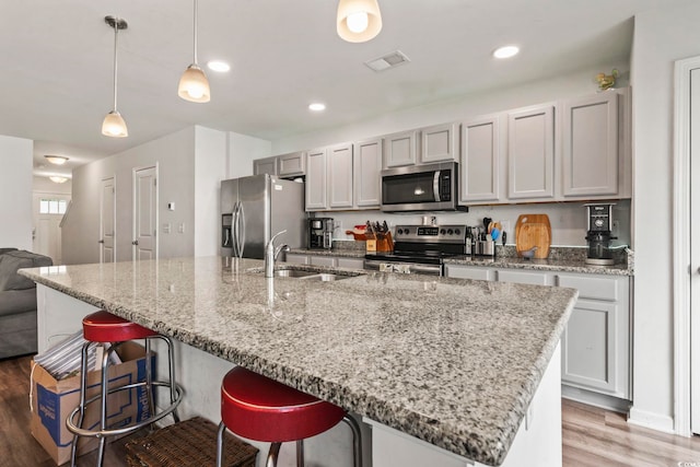 1117 Fairway Ln Unit 1117, Conway, SC 29526 - kitchen featuring appliances with stainless steel finishes, a breakfast bar, wood finished floors, a center island with sink, and recessed lighting