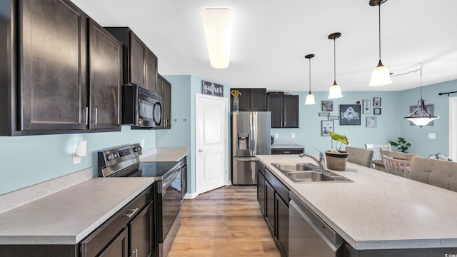 1201 Midtown Village Dr, Conway, SC 29526 - kitchen featuring stainless steel appliances, light wood-type flooring, dark brown cabinetry, pendant lighting, and light countertops