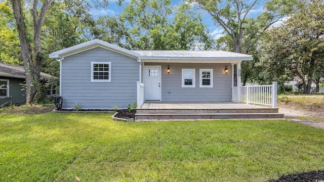 1553 Watson Ave, Little River, SC 29566 - view of front of property with a front yard, a wooden deck, and a metal roof