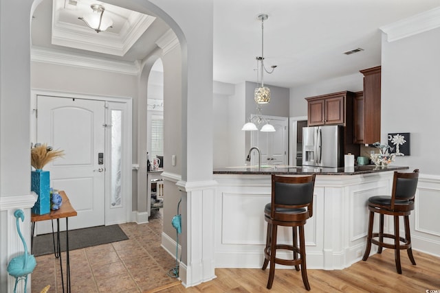 265 Venice Way Unit 1-404, Myrtle Beach, SC 29577 - kitchen with stainless steel fridge with ice dispenser, arched walkways, a kitchen bar, decorative light fixtures, and dark stone countertops