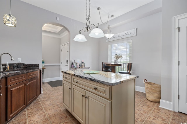 265 Venice Way Unit 1-404, Myrtle Beach, SC 29577 - kitchen featuring arched walkways, cream cabinets, dark stone countertops, crown molding, and pendant lighting