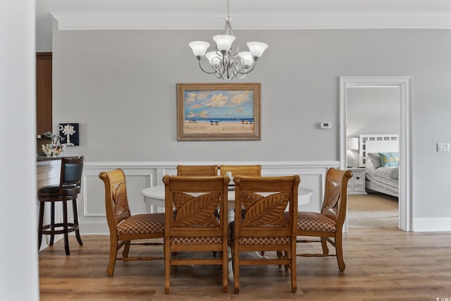 265 Venice Way Unit 1-404, Myrtle Beach, SC 29577 - dining area featuring ornamental molding, a chandelier, light wood-style flooring, a wainscoted wall, and a decorative wall