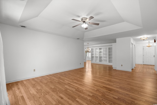 1415 Fox Hollow Way N, Myrtle Beach, SC 29582 - unfurnished living room with a chandelier, a ceiling fan, light wood-style floors, and a tray ceiling