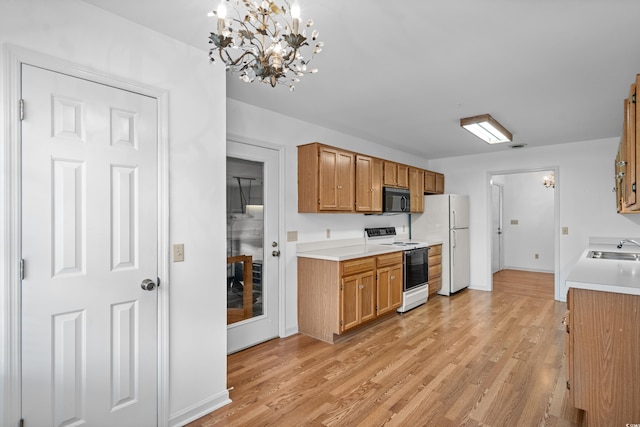1415 Fox Hollow Way N, Myrtle Beach, SC 29582 - kitchen featuring white appliances, light countertops, light wood-style floors, and a chandelier