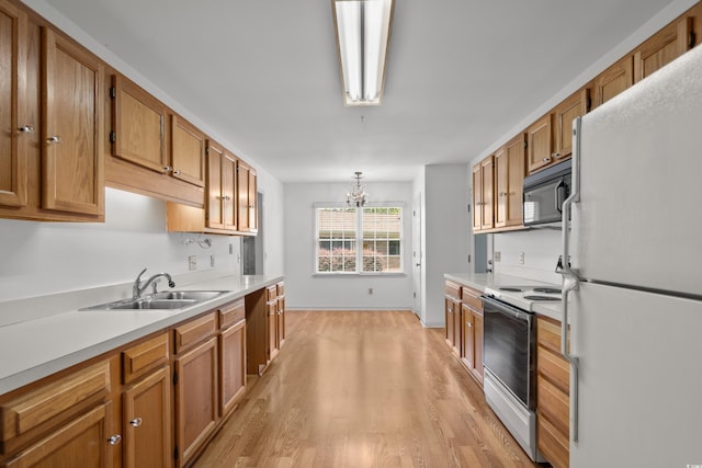1415 Fox Hollow Way N, Myrtle Beach, SC 29582 - kitchen with white appliances, light wood finished floors, a chandelier, light countertops, and brown cabinets