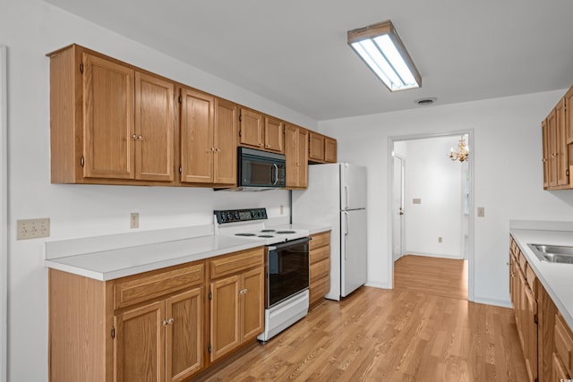 1415 Fox Hollow Way N, Myrtle Beach, SC 29582 - kitchen with white appliances, light countertops, light wood finished floors, a chandelier, and brown cabinets