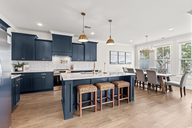 304 29th Ave N, North Myrtle Beach, SC 29582 - kitchen with appliances with stainless steel finishes, ornamental molding, a kitchen breakfast bar, blue cabinetry, and recessed lighting