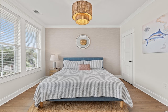 304 29th Ave N, North Myrtle Beach, SC 29582 - bedroom with multiple windows, wood finished floors, an accent wall, and crown molding