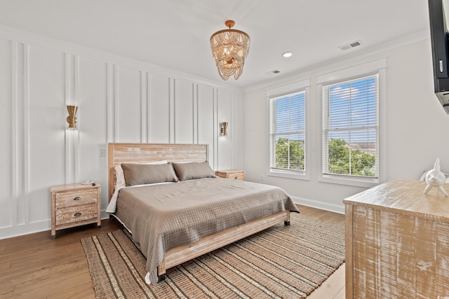 304 29th Ave N, North Myrtle Beach, SC 29582 - bedroom with light wood-type flooring, a decorative wall, crown molding, a chandelier, and recessed lighting