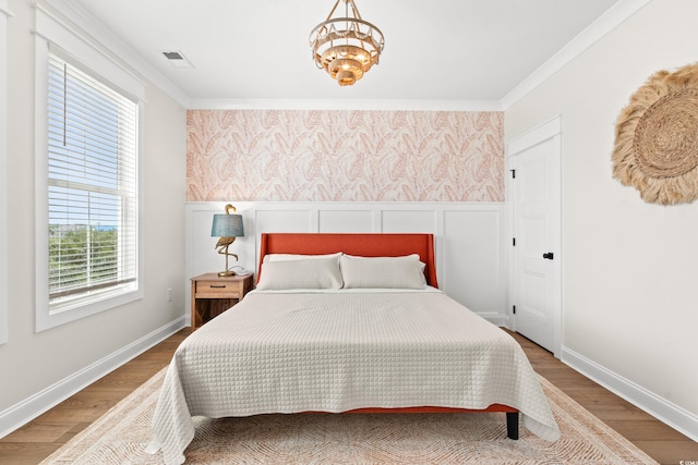 304 29th Ave N, North Myrtle Beach, SC 29582 - bedroom with wood finished floors, wallpapered walls, a chandelier, and ornamental molding