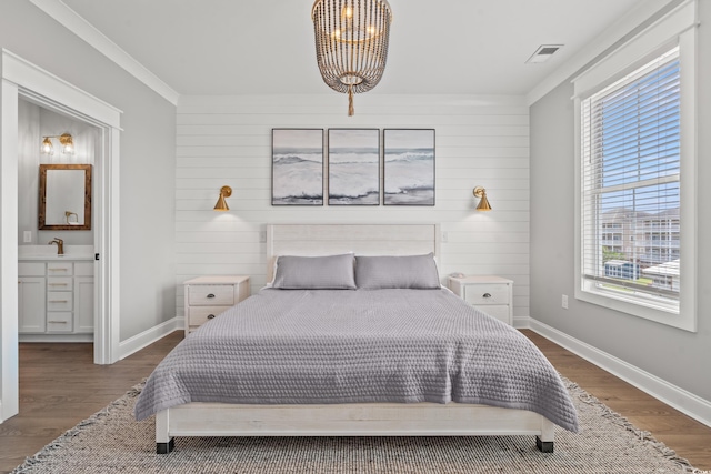 304 29th Ave N, North Myrtle Beach, SC 29582 - bedroom with a chandelier, wood finished floors, wooden walls, and ensuite bath