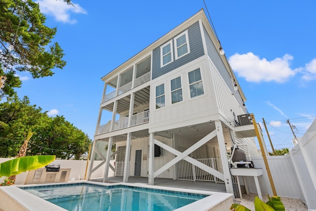 304 29th Ave N, North Myrtle Beach, SC 29582 - rear view of property featuring board and batten siding, a balcony, a fenced backyard, and stairs