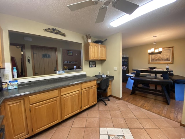 2232 Franklin Cir, Little River, SC 29566 - kitchen featuring dark countertops, light tile patterned floors, ceiling fan, a textured ceiling, and decorative light fixtures