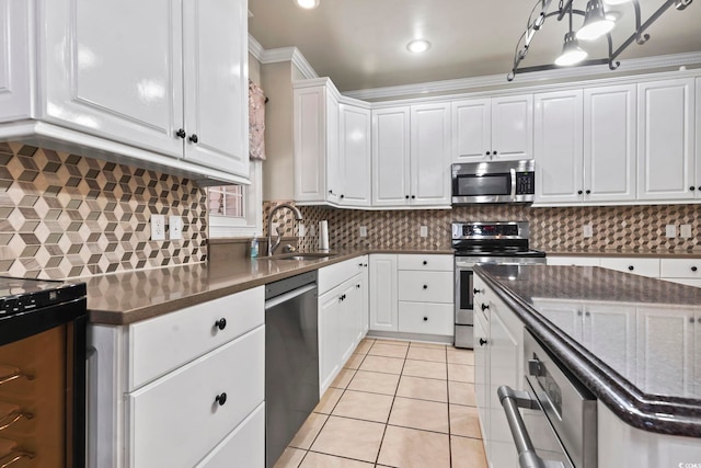 1504 27th Ave N, North Myrtle Beach, SC 29582 - kitchen featuring stainless steel appliances, white cabinetry, light tile patterned flooring, decorative backsplash, and dark stone counters