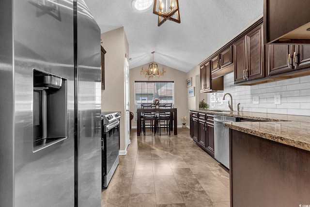 3922 Glenmere Dr, Myrtle Beach, SC 29588 - kitchen with stainless steel appliances, a chandelier, vaulted ceiling, light stone countertops, and dark brown cabinets