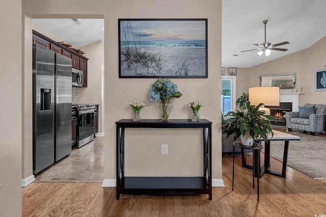 3922 Glenmere Dr, Myrtle Beach, SC 29588 - kitchen featuring appliances with stainless steel finishes, a lit fireplace, dark brown cabinets, lofted ceiling, and open floor plan