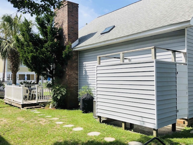 910 Perrin Dr, North Myrtle Beach, SC 29582 - view of property exterior with a chimney, a lawn, a deck, and a shingled roof