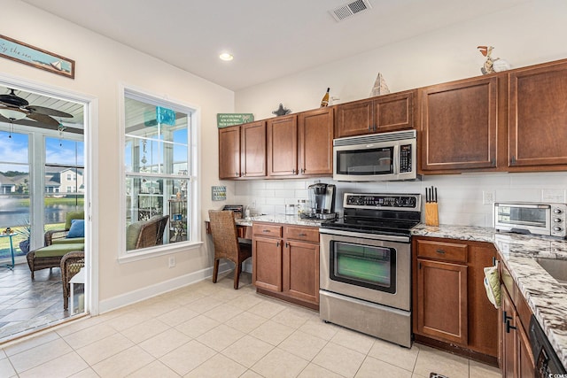 6014 Catalina Dr Unit 413, North Myrtle Beach, SC 29582 - kitchen featuring stainless steel appliances, backsplash, light stone countertops, ceiling fan, and light tile patterned floors