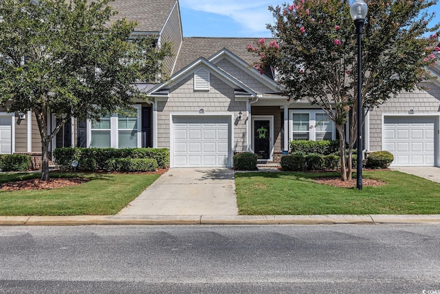 6014 Catalina Dr Unit 413, North Myrtle Beach, SC 29582 - view of front facade with concrete driveway, a garage, a front lawn, and a shingled roof