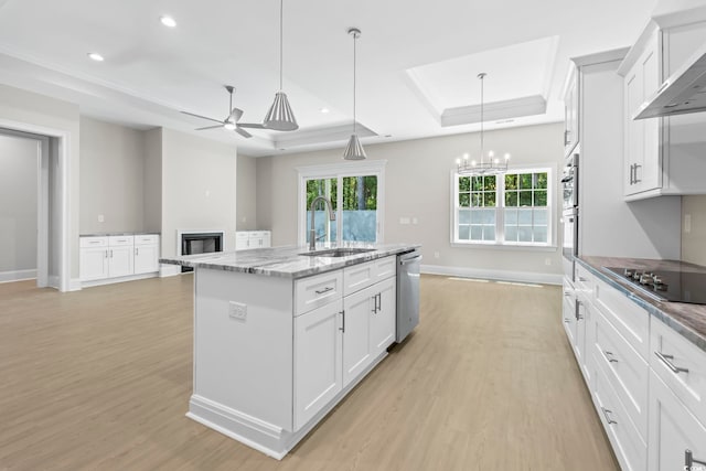 293 Waterfall Cir, Little River, SC 29566 - kitchen featuring black electric cooktop, a tray ceiling, wall chimney exhaust hood, light wood-style flooring, and recessed lighting