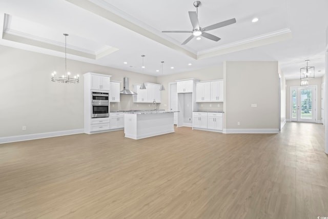 293 Waterfall Cir, Little River, SC 29566 - unfurnished living room with a raised ceiling, ornamental molding, light wood-style floors, ceiling fan, and a chandelier