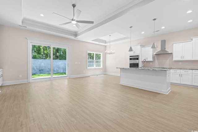 293 Waterfall Cir, Little River, SC 29566 - unfurnished living room with a tray ceiling, a ceiling fan, light wood finished floors, recessed lighting, and a chandelier
