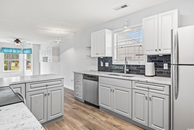 603 Bucks Trl, Longs, SC 29568 - kitchen with stainless steel appliances, ceiling fan, light wood-style floors, tasteful backsplash, and white cabinets