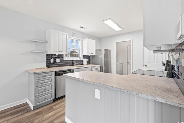 603 Bucks Trl, Longs, SC 29568 - kitchen featuring stainless steel appliances, a peninsula, open shelves, wood finished floors, and tasteful backsplash