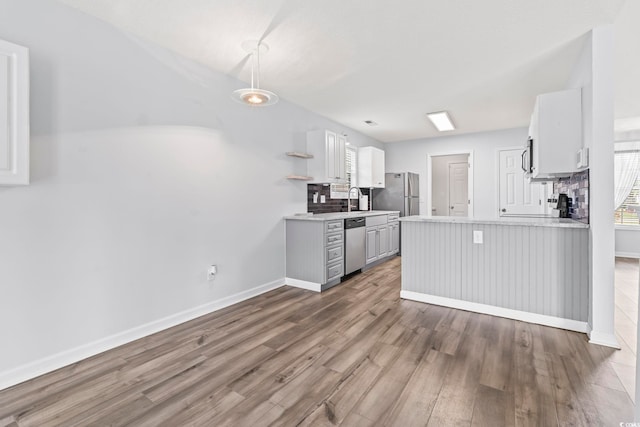 603 Bucks Trl, Longs, SC 29568 - kitchen featuring stainless steel appliances, wood finished floors, light countertops, open shelves, and a peninsula