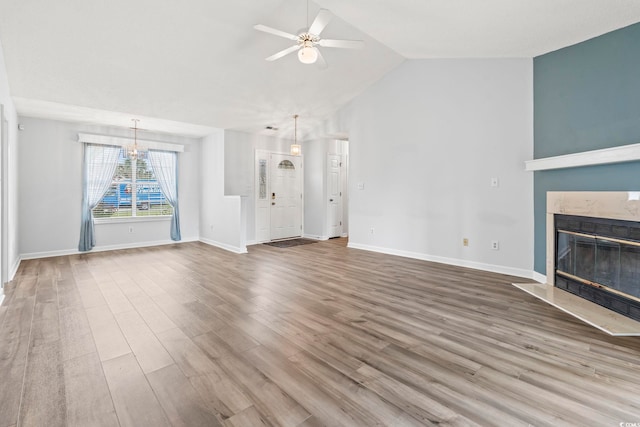 603 Bucks Trl, Longs, SC 29568 - unfurnished living room featuring a high end fireplace, ceiling fan, lofted ceiling, wood finished floors, and a chandelier