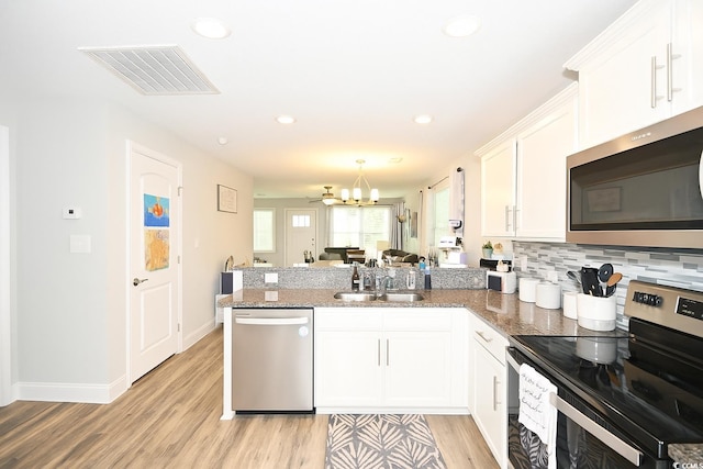 1300 Floyd Page Rd, Galivants Ferry, SC 29544 - kitchen with appliances with stainless steel finishes, a peninsula, light wood-style flooring, white cabinets, and light stone counters