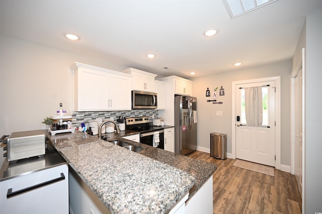 1300 Floyd Page Rd, Galivants Ferry, SC 29544 - kitchen with stainless steel appliances, a peninsula, wood finished floors, tasteful backsplash, and white cabinetry