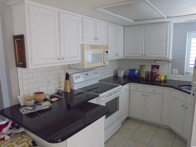 1004 Edge Dr, North Myrtle Beach, SC 29582 - kitchen featuring white appliances, white cabinetry, dark countertops, and tasteful backsplash