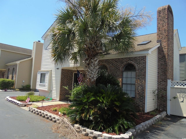 1004 Edge Dr, North Myrtle Beach, SC 29582 - view of front of home featuring brick siding, a chimney, and driveway