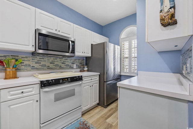 4430 Turtle Ln Unit 2-C, Little River, SC 29566 - kitchen featuring appliances with stainless steel finishes, white cabinets, decorative backsplash, light wood-type flooring, and light countertops