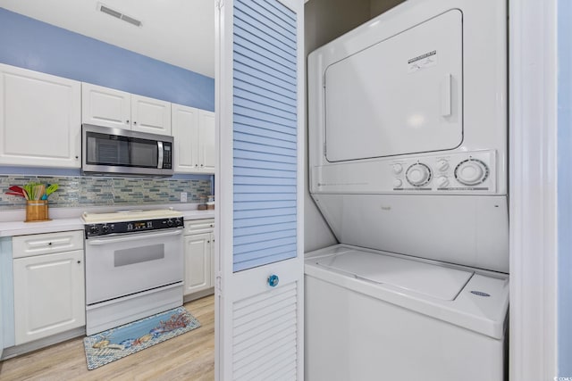 4430 Turtle Ln Unit 2-C, Little River, SC 29566 - washroom with stacked washer and clothes dryer and light wood-type flooring