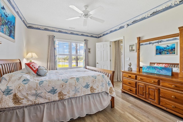 4430 Turtle Ln Unit 2-C, Little River, SC 29566 - bedroom with light wood-type flooring, a textured ceiling, and ceiling fan