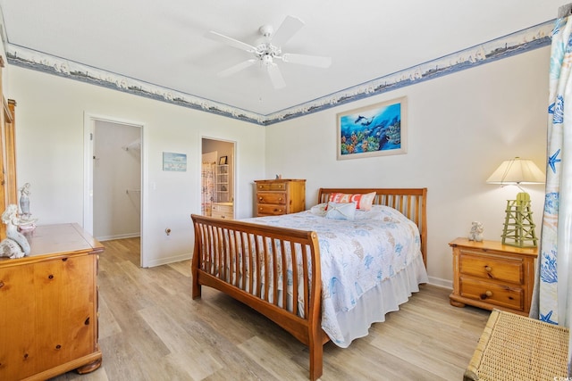 4430 Turtle Ln Unit 2-C, Little River, SC 29566 - bedroom featuring light wood-style flooring, a spacious closet, ensuite bathroom, and ceiling fan