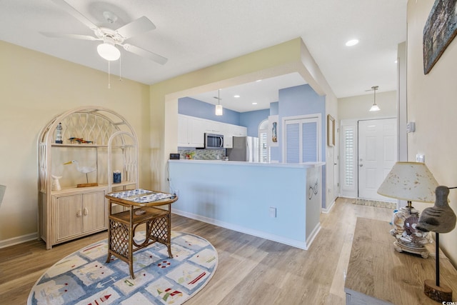 4430 Turtle Ln Unit 2-C, Little River, SC 29566 - kitchen with appliances with stainless steel finishes, light wood-style flooring, ceiling fan, white cabinetry, and a peninsula