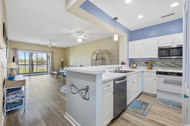 4430 Turtle Ln Unit 2-C, Little River, SC 29566 - kitchen featuring stainless steel appliances, open floor plan, a peninsula, tasteful backsplash, and light wood finished floors