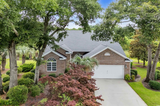 192 Hamby Dr, Pawleys Island, SC 29585 - view of front of house featuring brick siding, a garage, roof with shingles, and concrete driveway