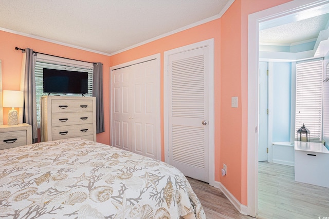 415 Ocean Creek Dr Unit 2373, Myrtle Beach, SC 29572 - bedroom featuring light wood finished floors, crown molding, multiple closets, and a textured ceiling