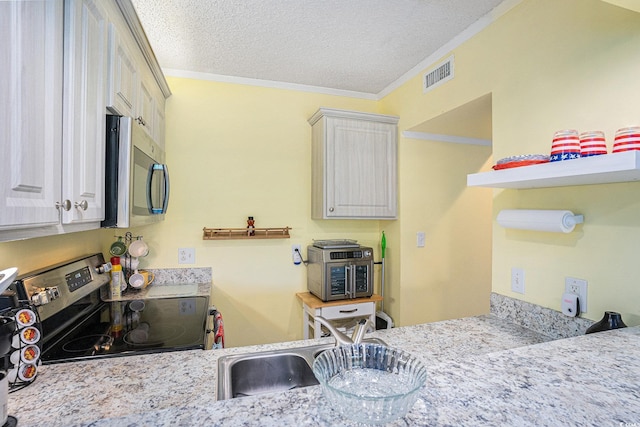 415 Ocean Creek Dr Unit 2373, Myrtle Beach, SC 29572 - kitchen with stainless steel appliances, crown molding, a textured ceiling, and light stone countertops